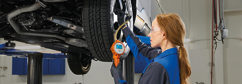 A Subaru technician checking tire pressure. | Armstrong Subaru in McMinnville OR