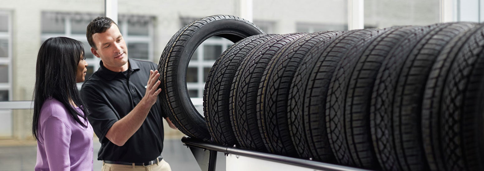 Subaru service representative showing customer a tire. | Armstrong Subaru in McMinnville OR